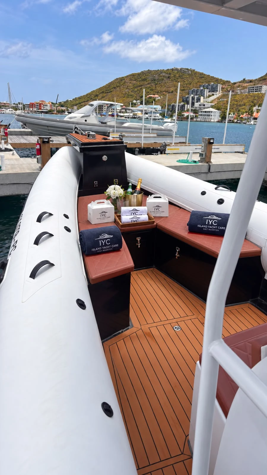 Island Yacht Care concierge setup with branded towels, flowers and refreshments aboard a yacht in Sint Maarten.